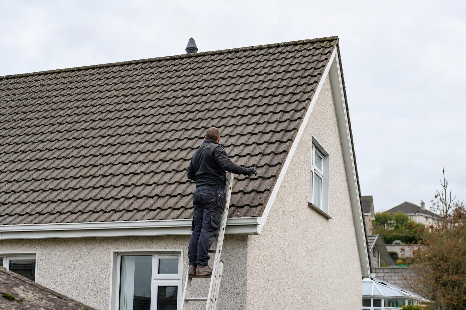 Roofer inspecting a tiled roof on an Irish home